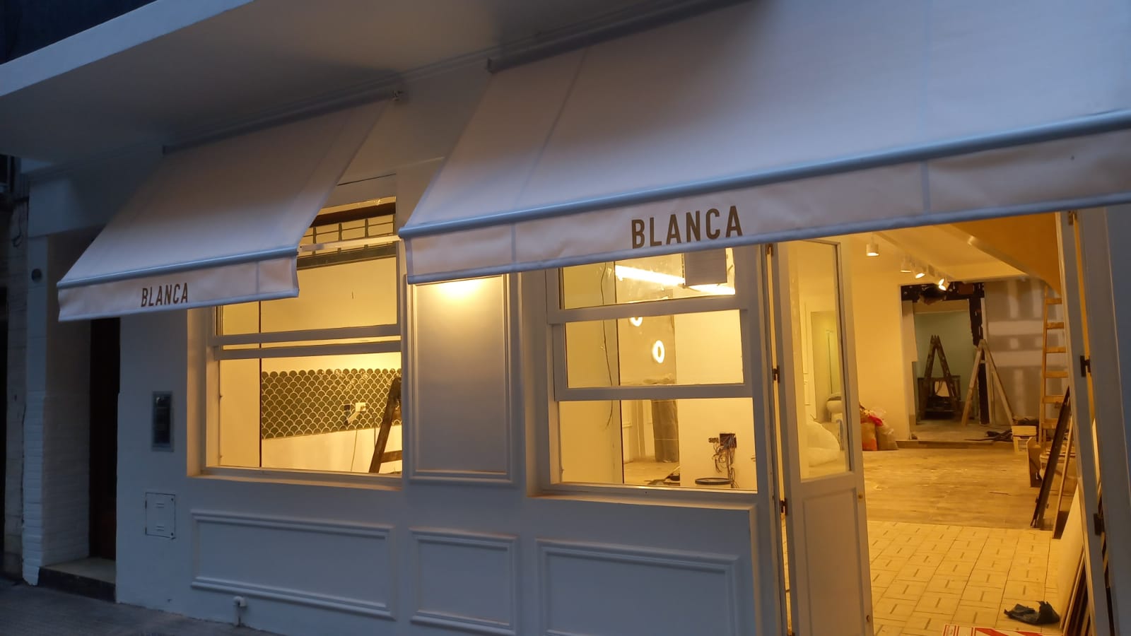 Toldo punto recto en comercio con logo personalizado